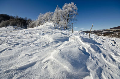 Scenic view of snow covered field against sky