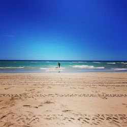 Scenic view of beach against clear blue sky