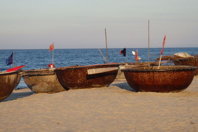 Boats moored on sandy beach