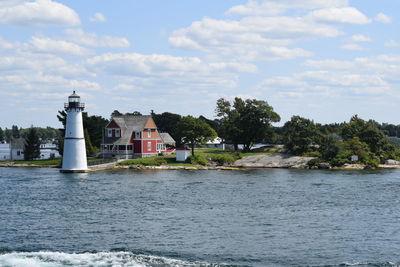 Buildings by sea against sky