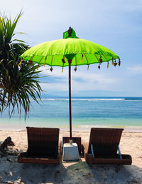 Chair on beach against sky