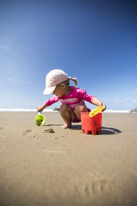 Young girl digging and playing at the beach.