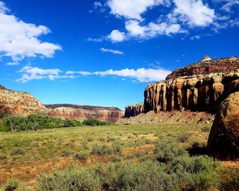 Rock formations on landscape against blue sky