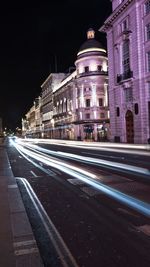 Light trails on road along buildings at night