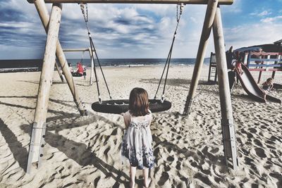 Rear view of boy playing on beach