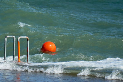 Orange ball floating on sea