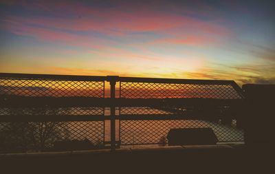 Close-up of silhouette fence against sky during sunset