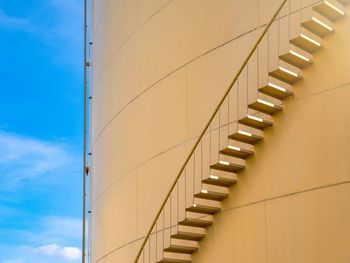 Low angle view of steps on silo against blue sky