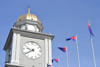 Low angle view of clock tower against clear blue sky
