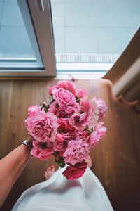 Close-up of hand holding pink flower bouquet