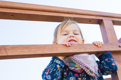 Portrait of cute girl playing on wood