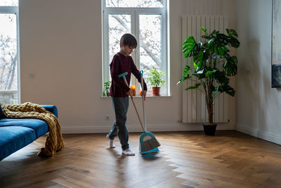 Side view of young woman with suitcase at home