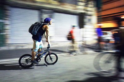 Blurred motion of people riding bicycle on road