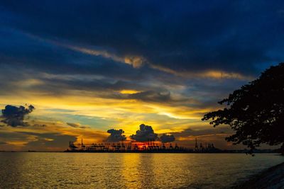 Scenic view of sea by buildings against sky during sunset