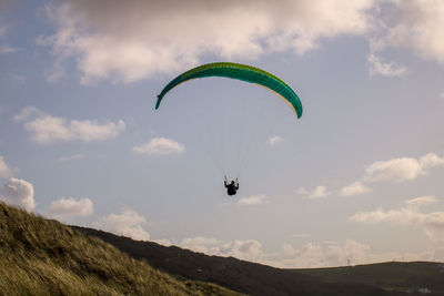 Person paragliding against sky