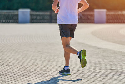 Running man. athletic man jogging in sportswear on city road. healthy lifestyle, fitness sport hobby