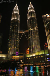 Low angle view of illuminated buildings against sky at night