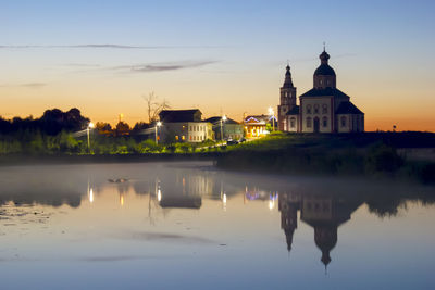 Night town is reflected in the lake. beautiful sunset and fog over the lake. peace and tranquility