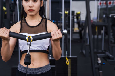 Midsection of young woman exercising in gym