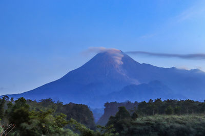 Scenic view of mountains against blue sky