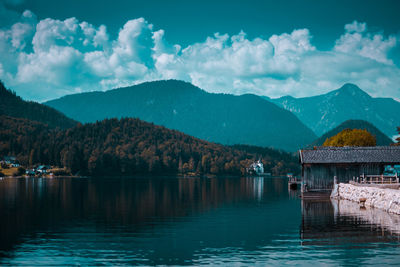 Scenic view of lake by mountains against sky