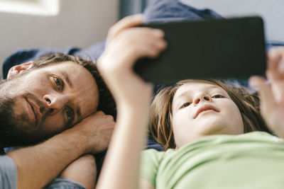 Father and son looking at smartphone together at home