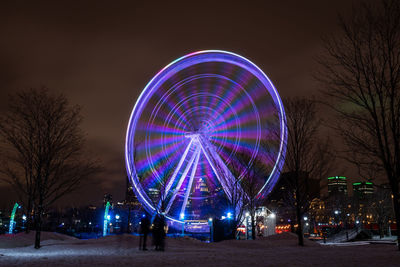 Illuminated ferris wheel at night