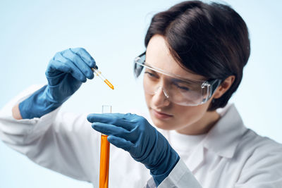 Close-up of doctor holding dentures against white background