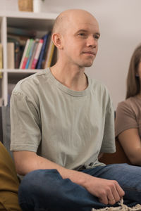 Portrait of young man sitting on sofa at home