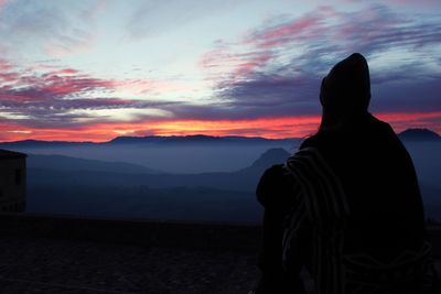 Rear view of silhouette woman against sky during sunset