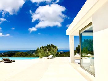 Scenic view of swimming pool by building against sky