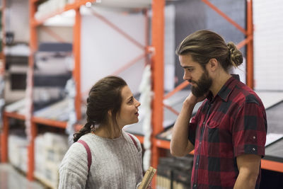 Couple looking at each other while standing in hardware store