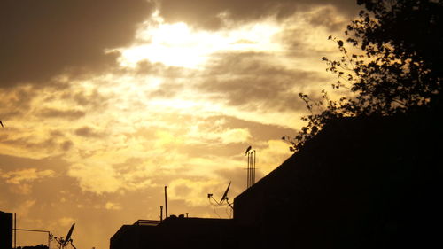 Silhouette of building against cloudy sky