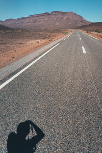 Shadow of man on road