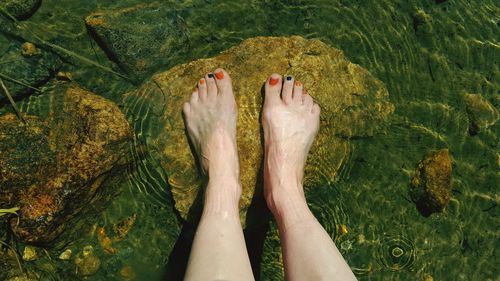 Low section of woman legs in water