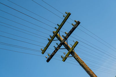 A wooden, electric pole by the railroad tracks