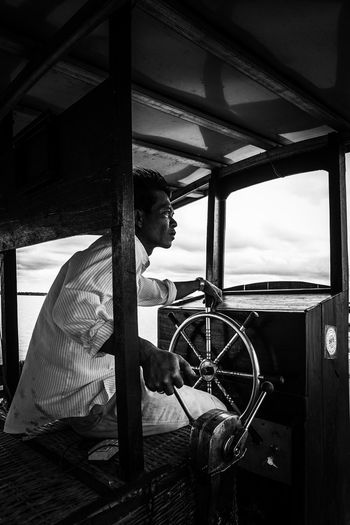 SIDE VIEW OF MAN WORKING WITH BOAT