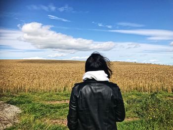 Rear view of man on field against sky