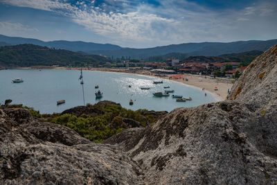 Scenic view of bay and mountains against sky