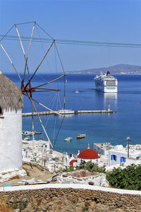 Buildings by sea against clear blue sky