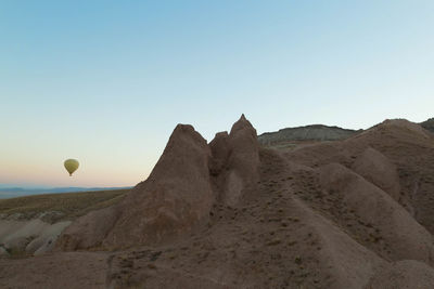 Scenic view of rock formations against clear sky during sunset