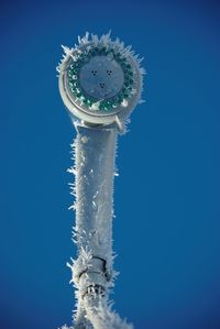 Low angle view of christmas tree against clear blue sky