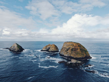 Rocks in sea against sky