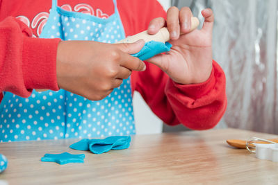 Midsection of girl playing with play clay on table