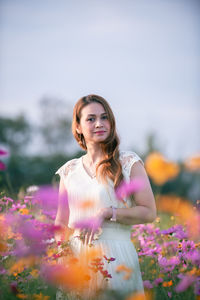 Portrait of a beautiful young woman with pink flower