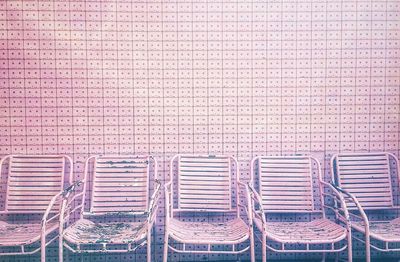 High angle view of chairs on table against brick wall