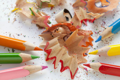 High angle view of multi colored pencils and shavings on table