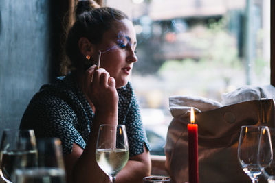 Portrait of woman drinking glass in restaurant