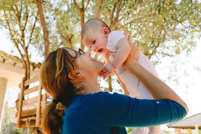 Mother and daughter against trees