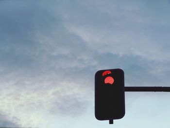 Low angle view of stoplight against sky